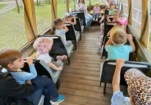 Dzieci siedzą w wozie.