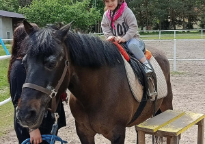 Dziecko siedzi na koniu.