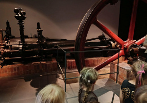 Dzieci oglądają eksponaty w muzeum.
