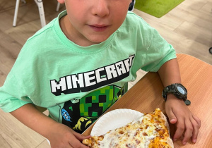 Chłopiec je pizzę.