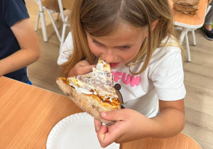 Dziewczynka je pizzę.
