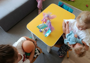 Dziewczynki trzymają w rękach lalki.