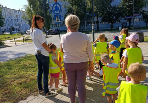 Dzieci stoją na chodniku.