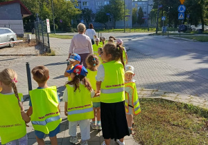 Dzieci idą chodnikiem.