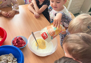 Dziewczynka dosypuje mango.