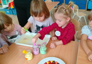 Dzieci nakładają pipetkami barwniki.