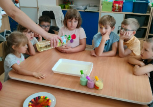 Nauczycielka wlewa olej do naczynia.