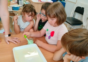 Dzieci nakładają pipetkami barwniki.
