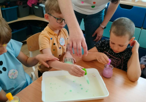 Dzieci nakładają pipetkami barwniki.