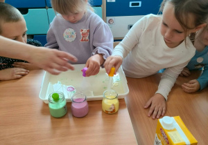 Dzieci nakładają pipetkami barwniki.
