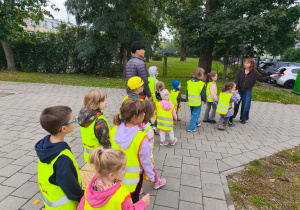 Nauczycielka tłumaczy dzieciom zasady przechodzenia przez ulicę.