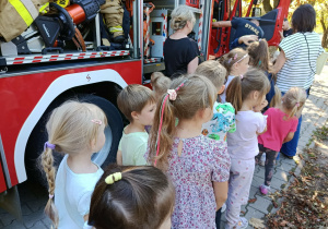 Dzieci oglądają wóz strażacki.