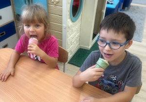 Dzieci jedzą lody.