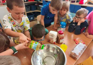 Dzieci dodają składniki do miski.