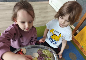 Dziewczynki wybierają warzywo, które będą chciały zjeść.