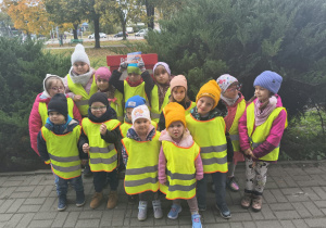 Dzieci stoją przy skrzynce pocztowej.