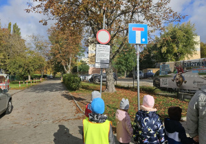 Dzieci oglądają znaki drogowe.