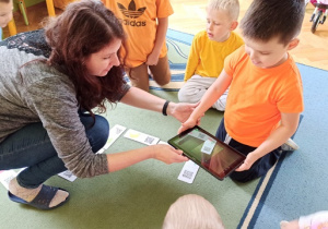 dzieci grają w domino z wykorzystaniem tabletu