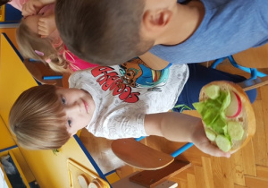 Chłopiec prezentuje przygotowaną kanapkę.