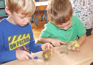 Chłopcy obierają ziemniaki.