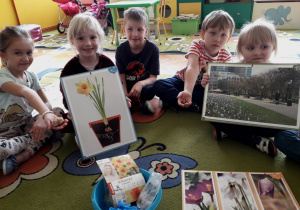 Dzieci oglądają zdjęcia kwiatów cebulowych.