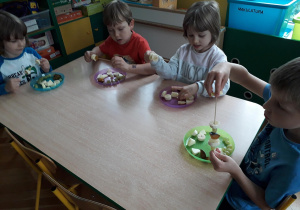 Dzieci wykonują szaszłyki owocowe