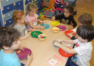 Dzieci samodzielnie układają emocje z wykorzystaniem gumowych warzyw i owoców.