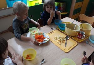 Dzieci robią sałatkę warzywną.