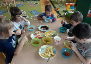 Dzieci jedzą sałatkę warzywną.