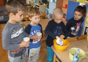 Chłopcy wlewają jogurt do galaretki.