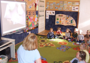 Dzieci oglądają film na tablicy multimedialnej.