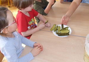 Dzieci degustują kiszone ogórki.
