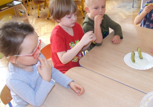 Dzieci degustują kiszone ogórki.