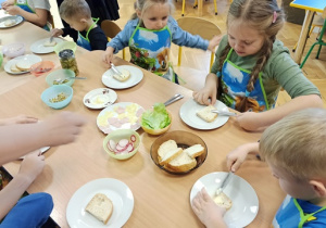 dzieci smarują pieczywo masłem