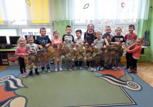 Dzieci prezentują zrobiony przez siebie szal