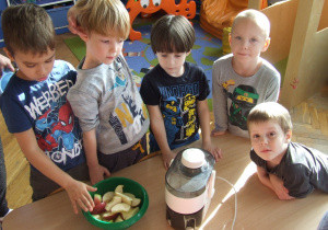 Dzieci czekają na wyciskanie soku jabłkowego.