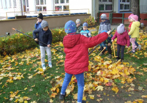 Dzieci grabią liście.