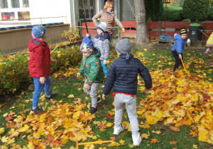Dzieci grabią liście.