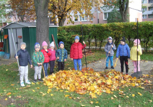 Wspólne grupowe zdjęcie przed nimi sterta liści.