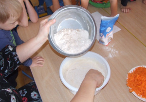 Nauczycielka wsypuje mąkę do miski.