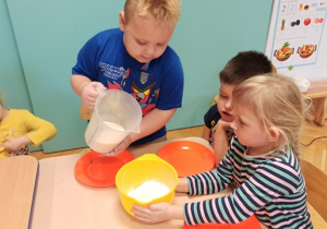 chłopiec wlewa mleko do miski