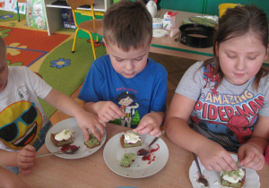 Dzieci dekorują ciasto.