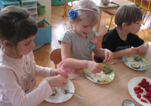Dzieci dekorują ciasto.
