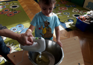 Chłopiec ubija białka jaj mikserem.