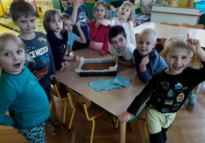 Dzieci pokazują upieczone ciasto marchewkowe.