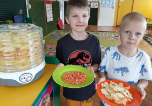 Chłopcy prezentują ususzoną marchewkę i jabłko