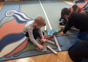 Dzieci bawią się klockami na dywanie