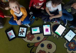 Dzieci pokazują misie narysowane na tabletach