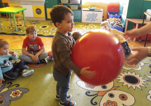 Dzieci grają w "pomidora" z dużą piłką