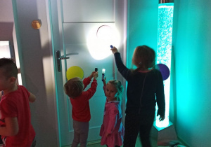 Dzieci świecą latarką na kolorowe koło